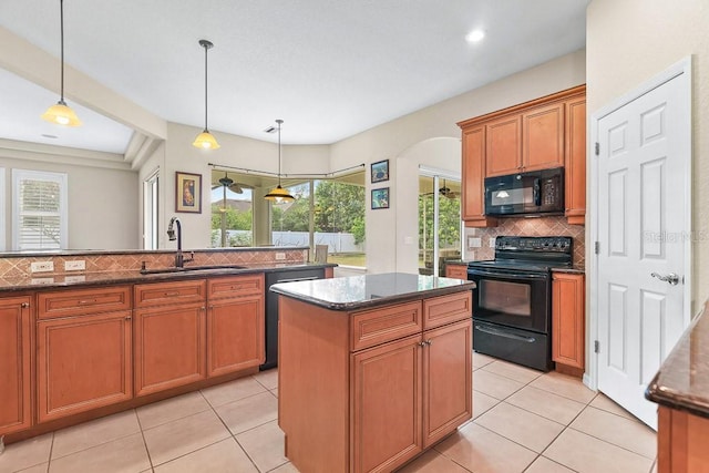 kitchen featuring pendant lighting, black appliances, sink, decorative backsplash, and light tile patterned floors