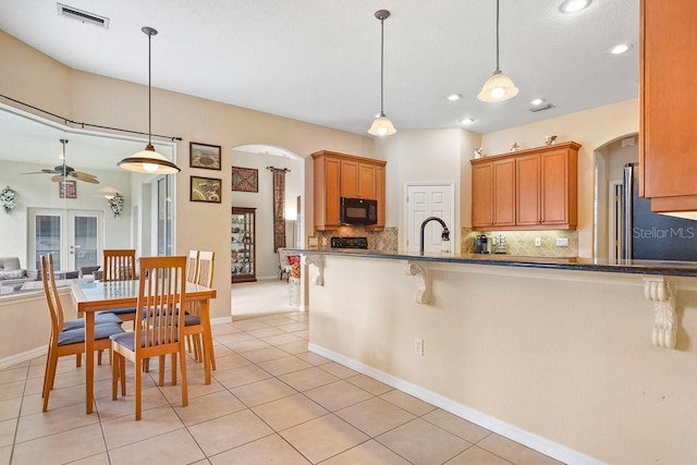 kitchen with pendant lighting, light tile patterned floors, tasteful backsplash, and high end refrigerator