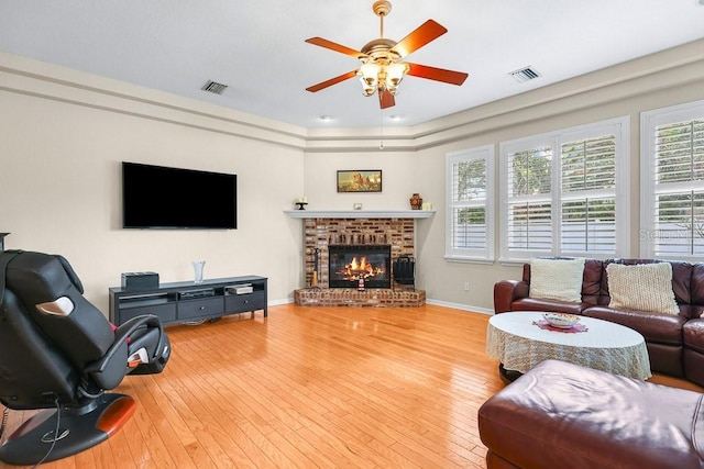 living room with a fireplace, wood-type flooring, and ceiling fan