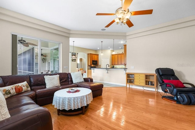 living room featuring light hardwood / wood-style flooring and ceiling fan