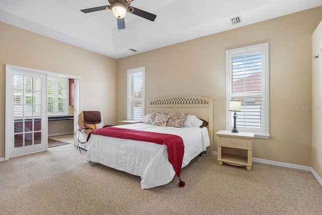 carpeted bedroom with multiple windows and ceiling fan