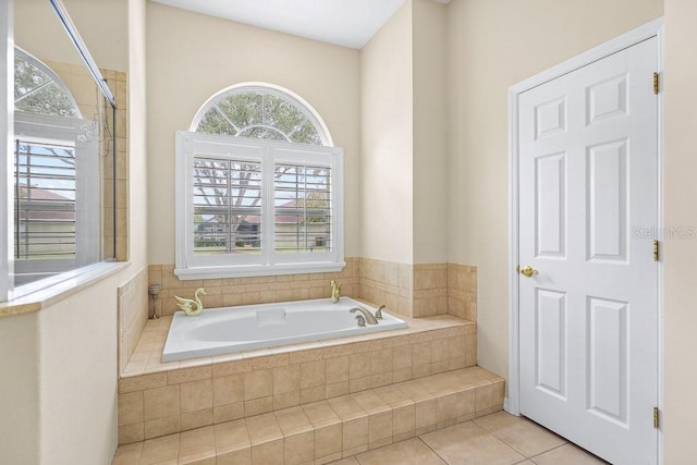 bathroom with tile patterned floors and tiled bath