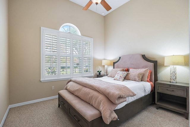 carpeted bedroom with ceiling fan and high vaulted ceiling