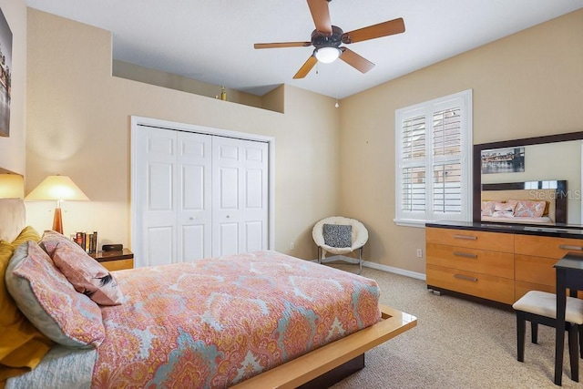 bedroom featuring ceiling fan, a closet, and light colored carpet