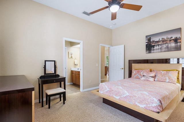 bedroom with light carpet, ensuite bathroom, and ceiling fan