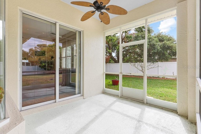 unfurnished sunroom with ceiling fan