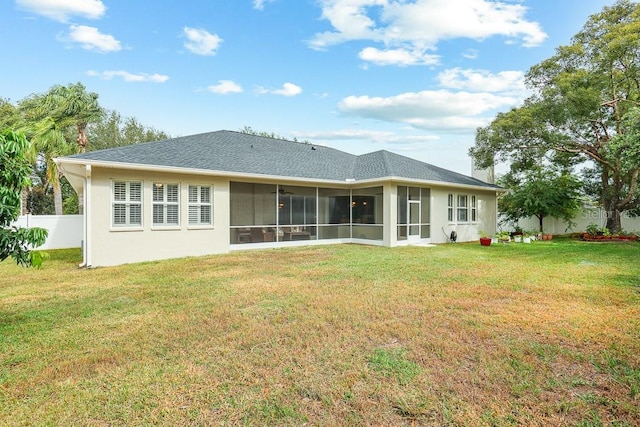 back of property with a sunroom and a yard