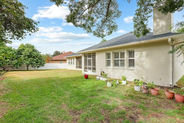 rear view of house with a sunroom and a lawn