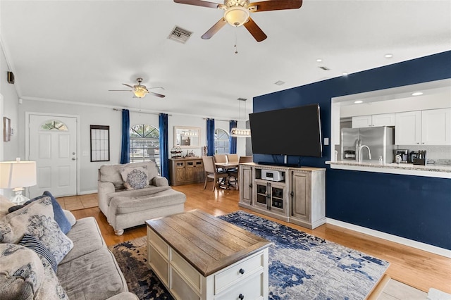 living room with ceiling fan, light hardwood / wood-style flooring, and ornamental molding