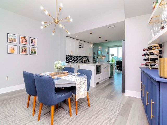 dining area with a chandelier and light wood-type flooring