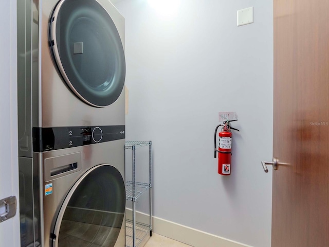 washroom with light tile patterned floors and stacked washing maching and dryer