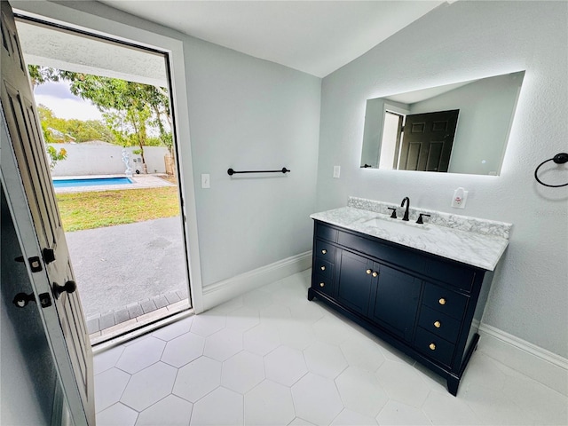 bathroom featuring vanity, tile patterned floors, and lofted ceiling