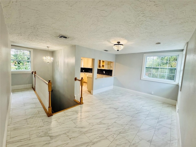 hall with a wealth of natural light and a chandelier