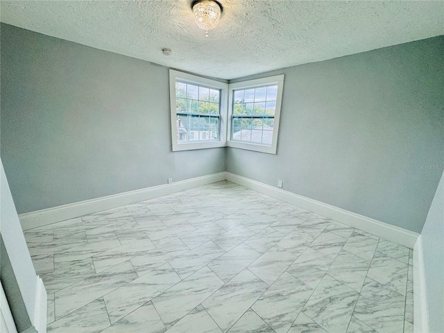 unfurnished room with a textured ceiling