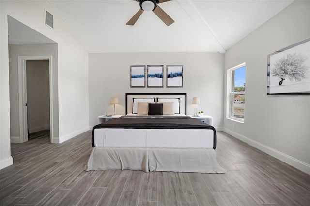 bedroom with visible vents, lofted ceiling, baseboards, and wood finished floors