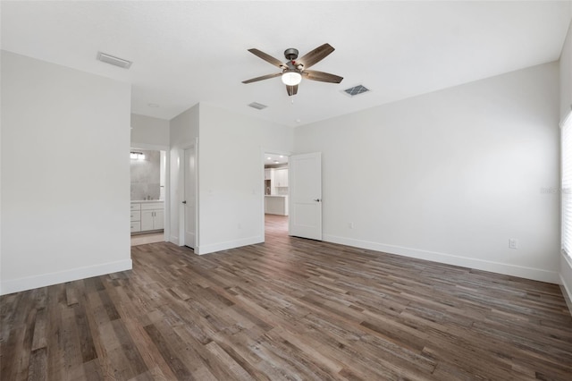 unfurnished bedroom featuring ensuite bath, dark wood-type flooring, and ceiling fan