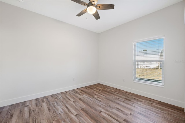 empty room featuring wood finished floors, a ceiling fan, and baseboards