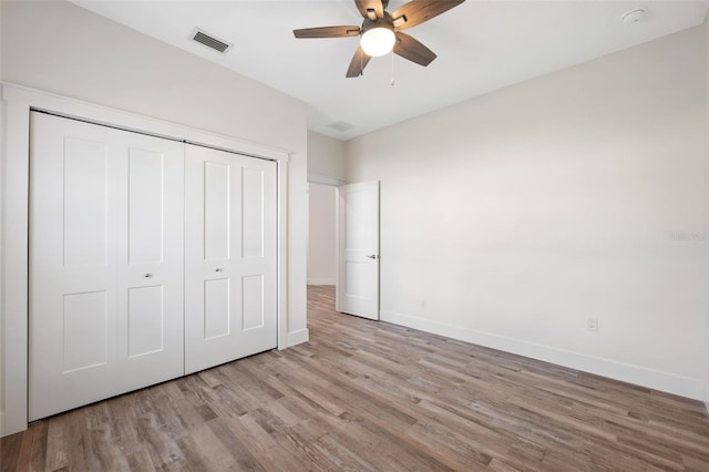 unfurnished bedroom featuring a closet, ceiling fan, and light wood-type flooring