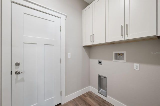 clothes washing area with electric dryer hookup, washer hookup, dark hardwood / wood-style flooring, and cabinets