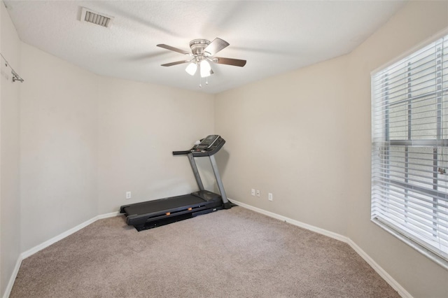 exercise area featuring ceiling fan and carpet