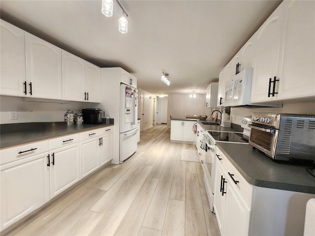 kitchen featuring light wood-type flooring, white appliances, white cabinetry, and sink