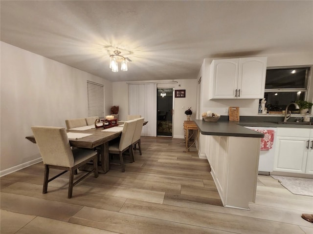 dining room with a chandelier, light hardwood / wood-style flooring, and sink