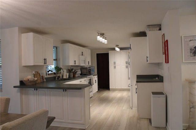 kitchen with kitchen peninsula, sink, white cabinets, and white appliances