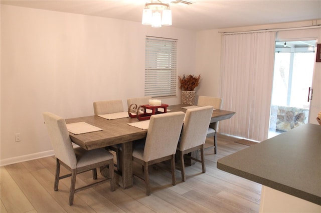 dining space with a notable chandelier and light hardwood / wood-style floors