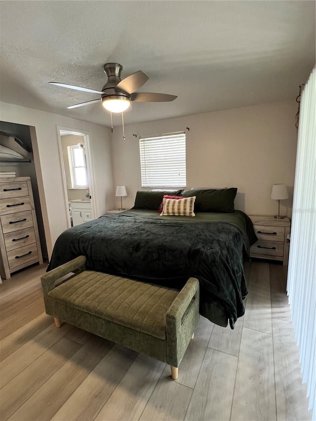 bedroom featuring multiple windows, ceiling fan, and light wood-type flooring