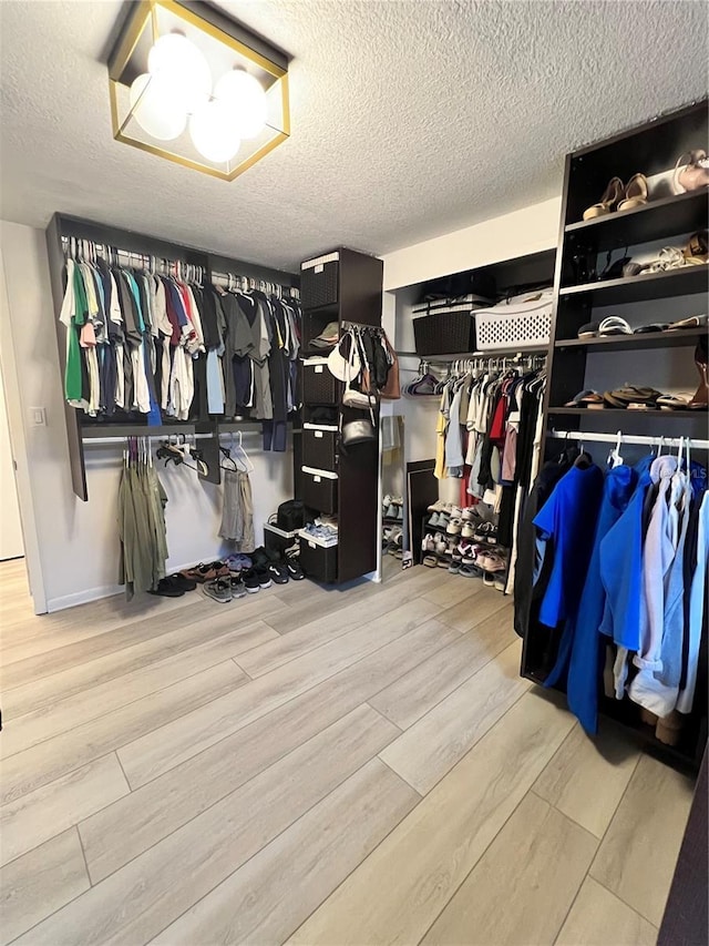 walk in closet featuring light hardwood / wood-style flooring