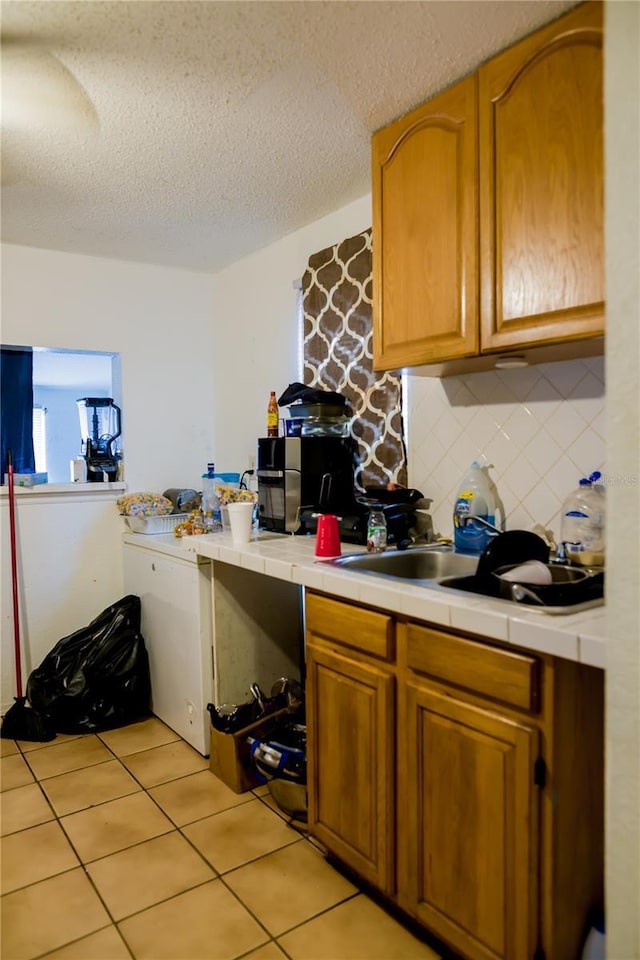 kitchen featuring backsplash, light tile patterned flooring, and a textured ceiling