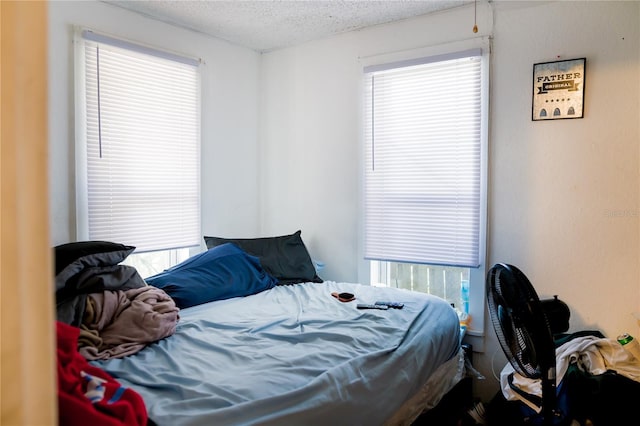 bedroom featuring multiple windows and a textured ceiling