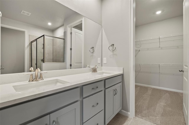 bathroom featuring a shower with door and vanity