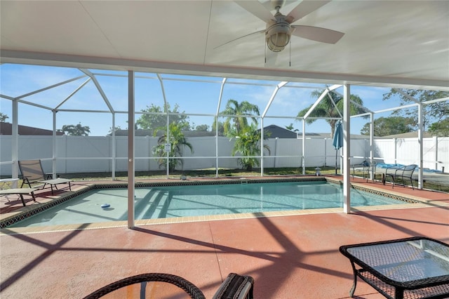 view of pool featuring glass enclosure, ceiling fan, and a patio area