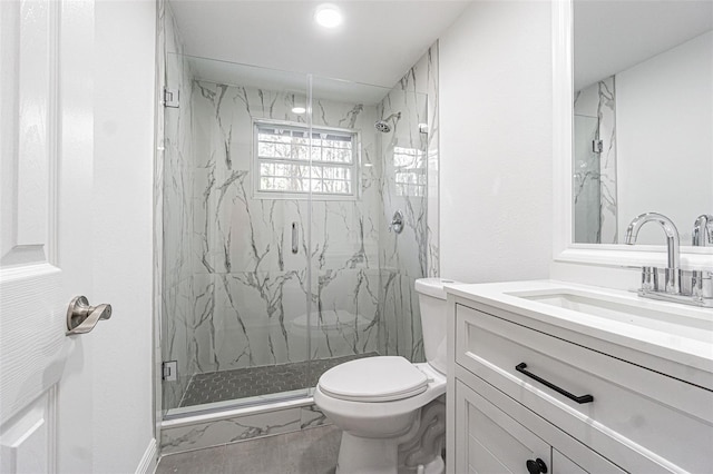 bathroom featuring a shower with door, vanity, and toilet