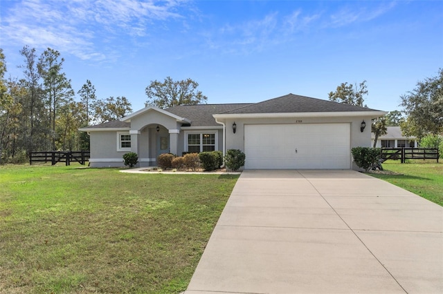 ranch-style home featuring stucco siding, fence, concrete driveway, a front yard, and a garage