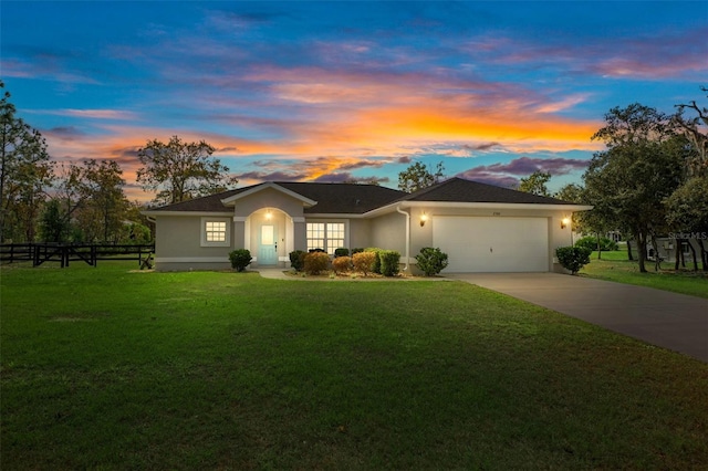 ranch-style house featuring stucco siding, concrete driveway, and a front lawn