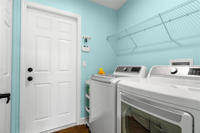 laundry room featuring washing machine and dryer and dark hardwood / wood-style floors