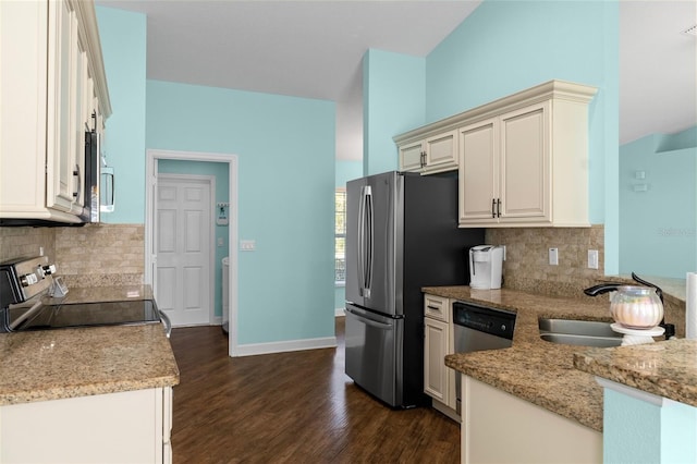 kitchen featuring light stone counters, dark wood-style floors, baseboards, a sink, and appliances with stainless steel finishes