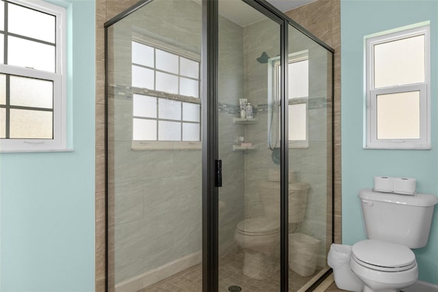 bathroom featuring a shower stall and toilet