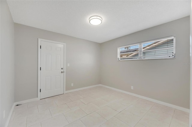 unfurnished room with a textured ceiling