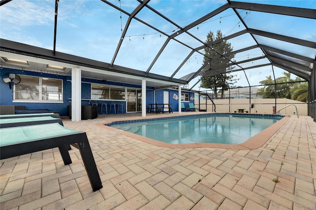 view of pool with an outdoor bar, a lanai, and a patio