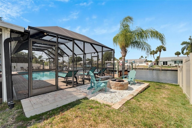 exterior space with a lanai, a fire pit, a water view, and a lawn