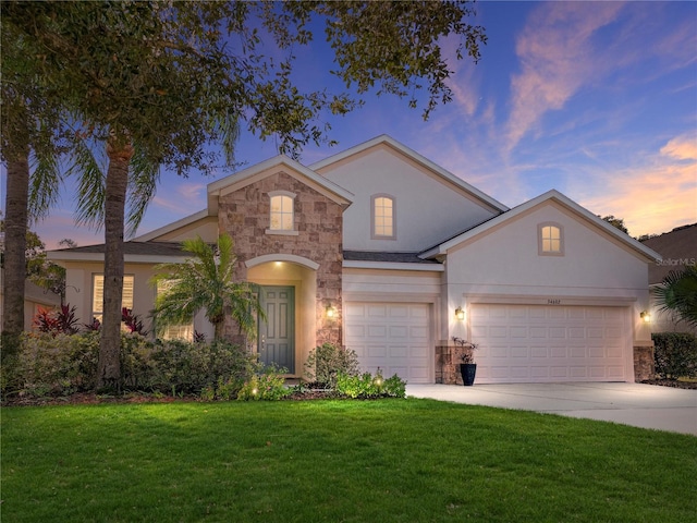 front facade featuring a lawn and a garage