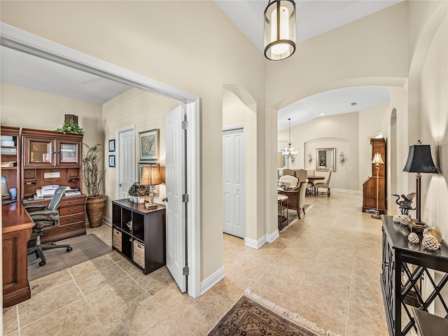 tiled home office with a high ceiling and an inviting chandelier