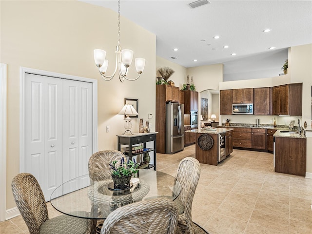 dining area with a chandelier, a high ceiling, and sink