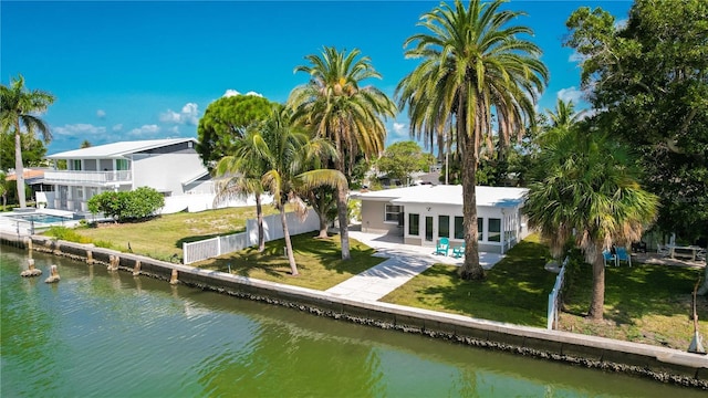 back of property featuring a lawn, a patio area, and a water view