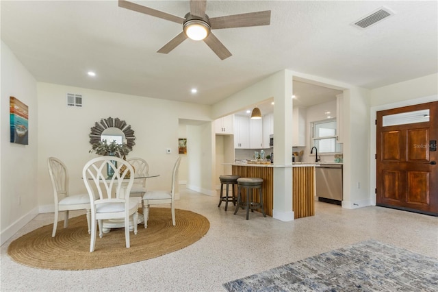 dining space with ceiling fan and sink