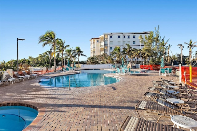 view of swimming pool featuring a patio and a hot tub