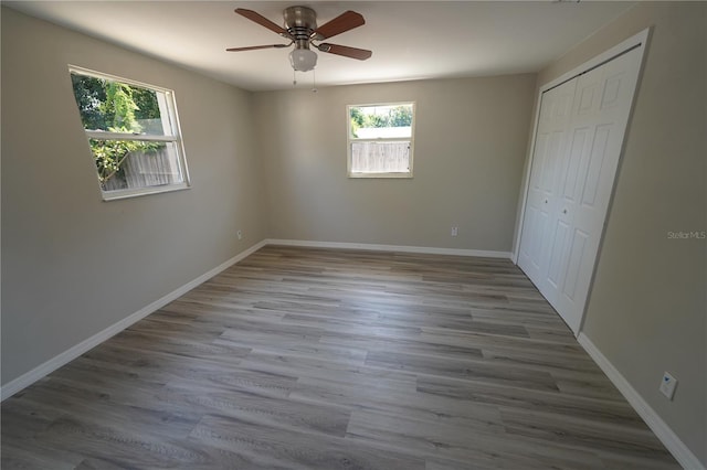 unfurnished bedroom with a closet, light hardwood / wood-style flooring, and ceiling fan